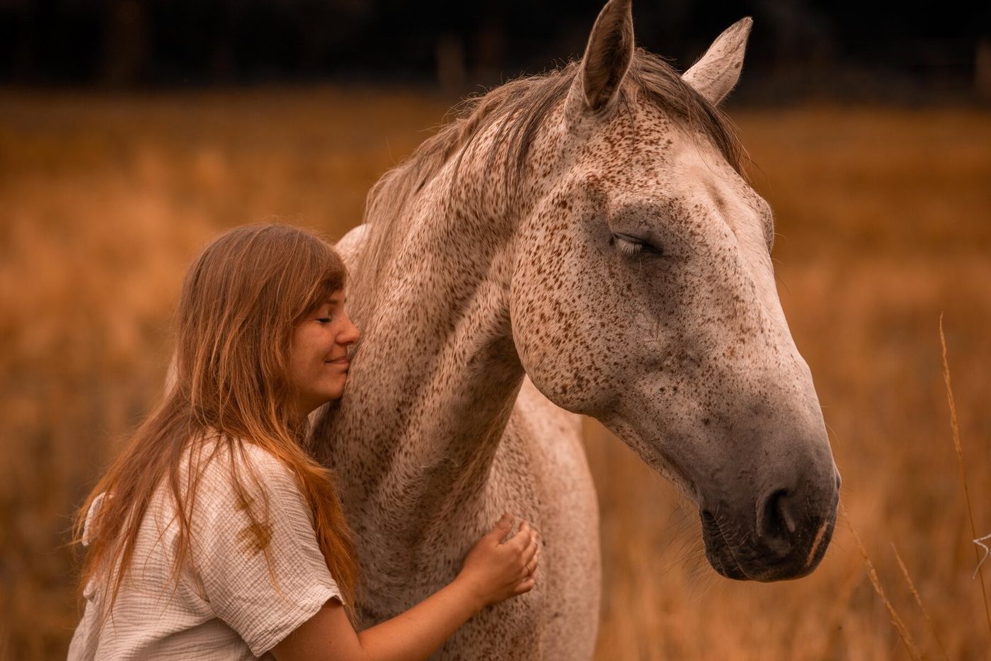 Ramona Stirn an Stirn mit ihrem Pferd im Feld